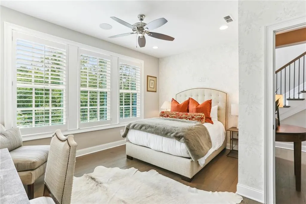 Bedroom featuring multiple windows, ceiling fan, and dark hardwood / wood-style floors