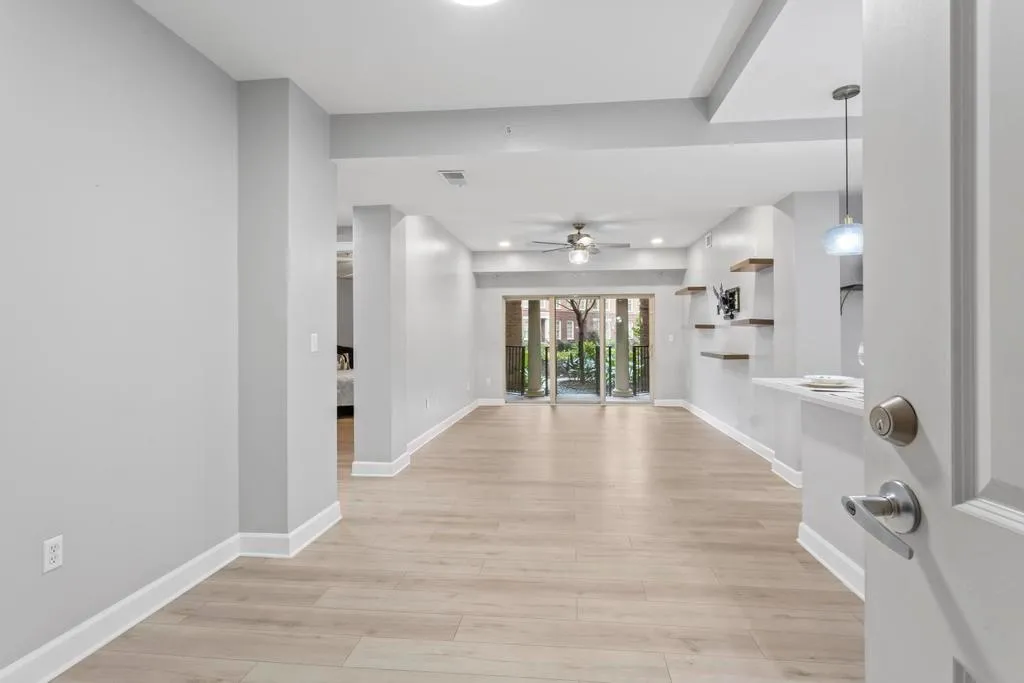 Foyer with light wide plank flooring and ceiling fan with additional recessed lights, shelves and mount ready for your tv
