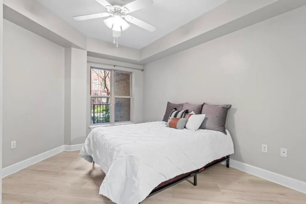 Bedroom #1 with light wood-type flooring and ceiling fan