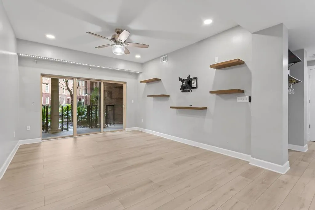 Unfurnished living room featuring ceiling fan and light wood-type flooring