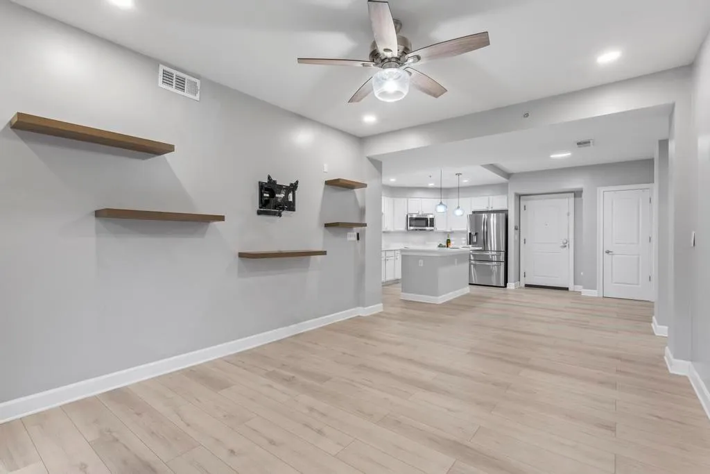 Unfurnished living room with light hardwood / wood-style floors and ceiling fan