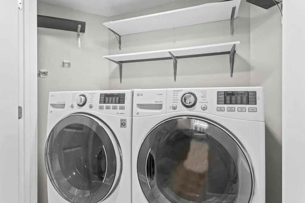 Laundry closet featuring washing machine and clothes dryer on pedestals