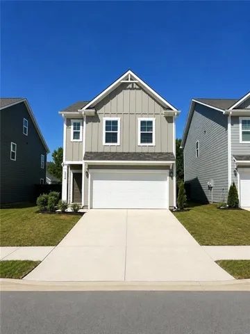 Two-story residence featuring light gray vertical siding and white trim