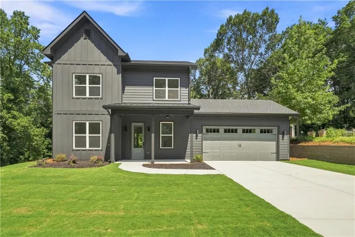 Modern farmhouse exterior with dark gray vertical and horizontal siding, an attached two-car garage, and a covered entry