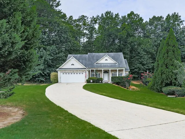 Traditional architectural style with a stone and siding facade, featuring a prominent two-car garage