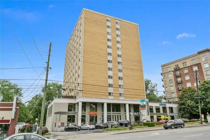 Mid-rise building featuring a light brick facade and numerous windows