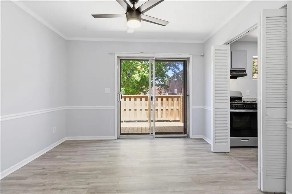 Doorway to outside with wood finished floors, a ceiling fan, and ornamental molding
