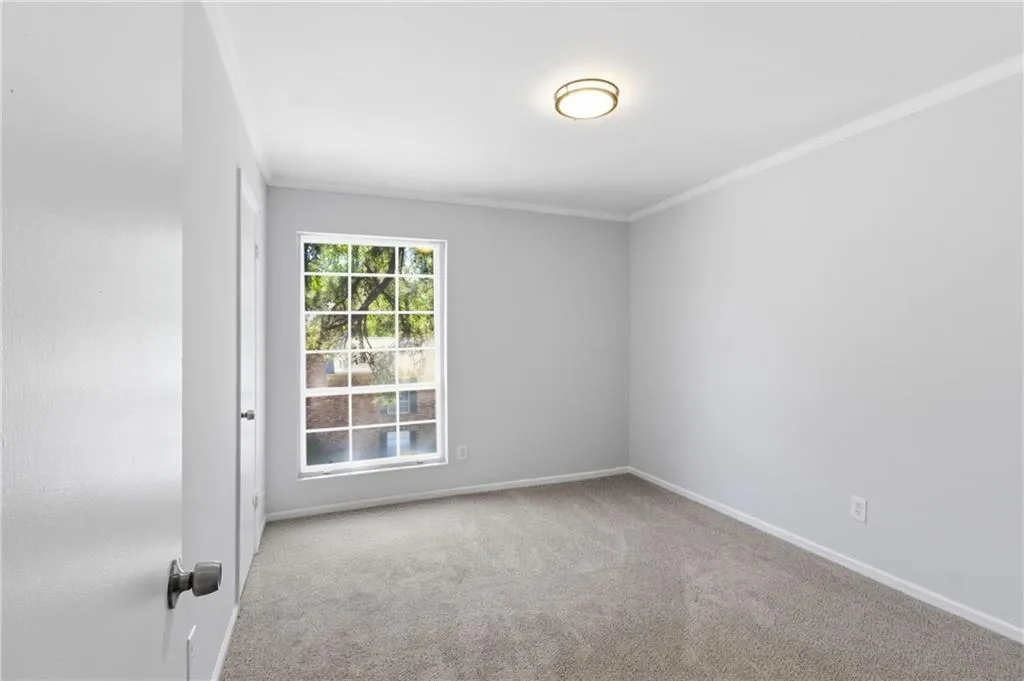 Unfurnished room featuring ornamental molding and light colored carpet
