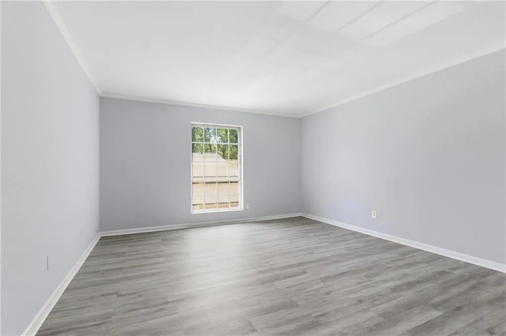 Unfurnished room featuring light wood-type flooring and ornamental molding