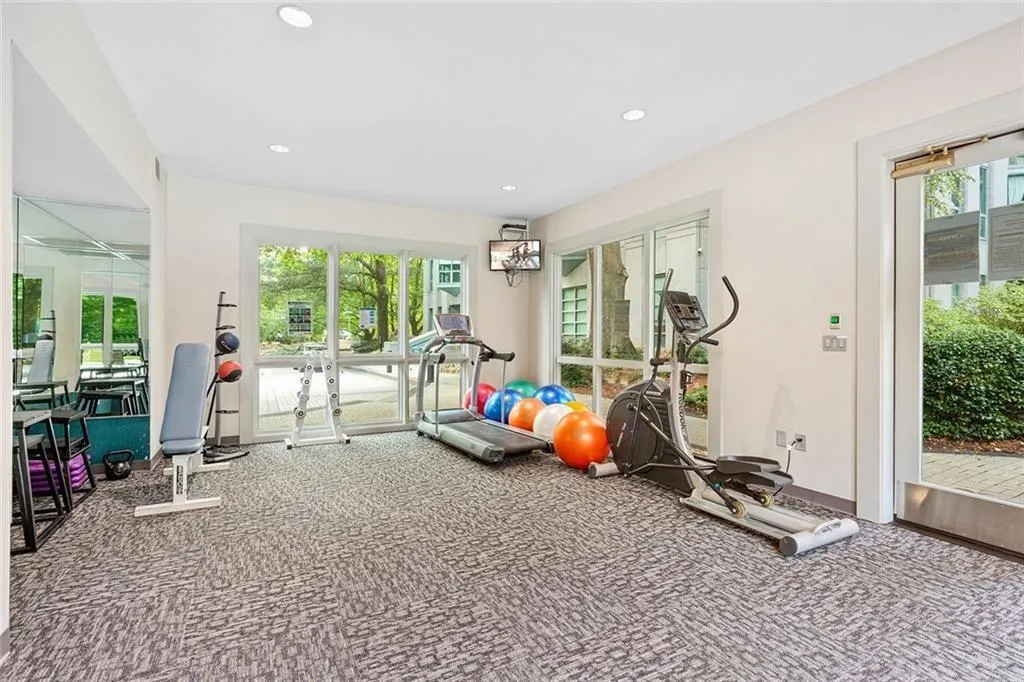 Fitness room featuring recessed lighting, wall-to-wall carpeting, floor-to-ceiling mirrors, and expansive windows