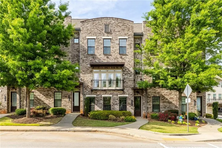 Brick exterior, multiple windows, front entry doors, manicured landscaping, paved walkways
