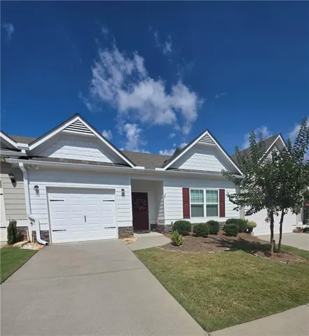 Exterior facade featuring white siding, a single-car garage, red window shutters, and a dark entry door