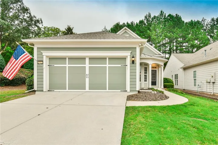 Siding exterior with a two-car garage featuring frosted glass panels, a concrete driveway, and a paved walkway leading to the front entry