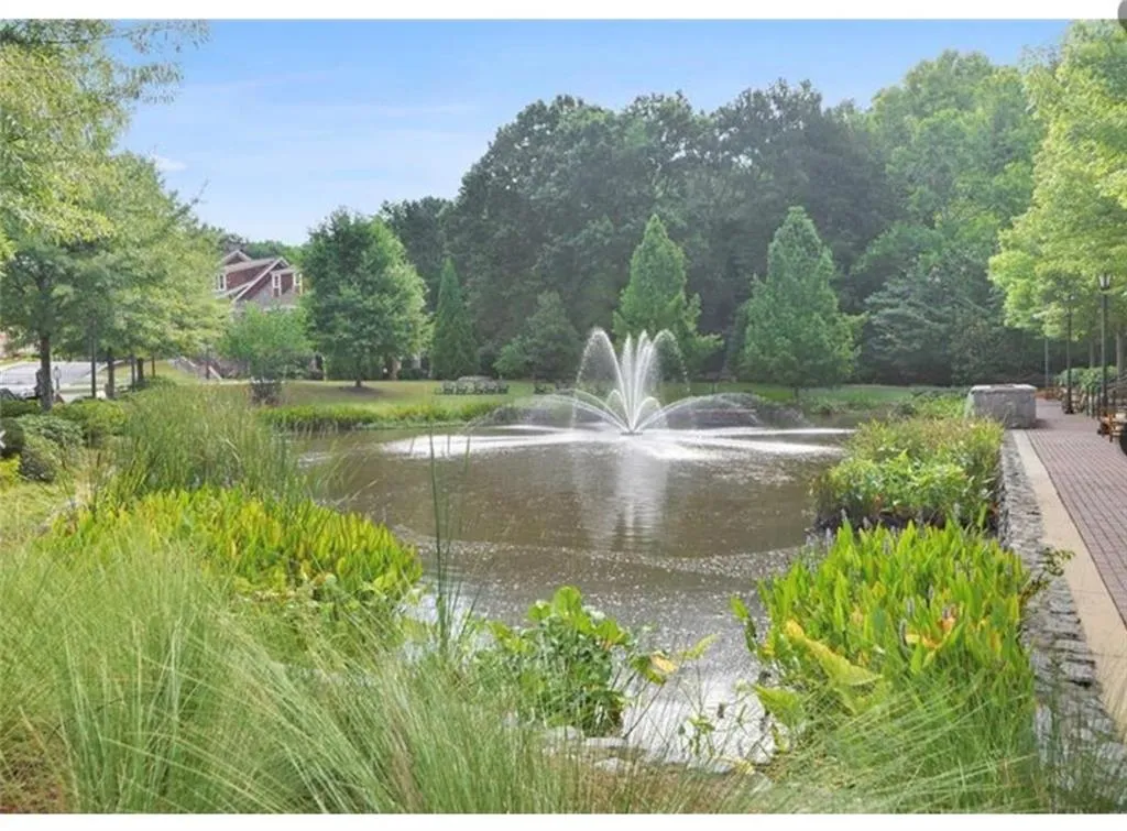 Surrounding community featuring a water view and view of wooded area