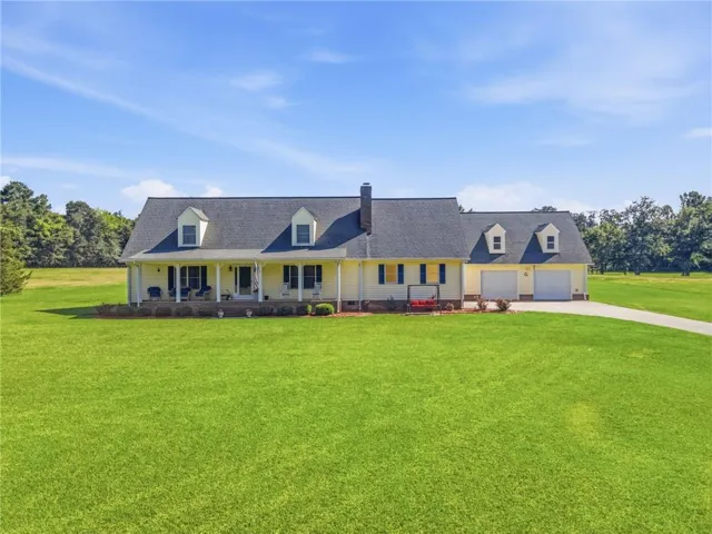 Ranch-style residence featuring a prominent covered front porch and dormer windows