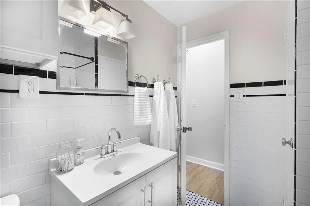 Bathroom featuring tile walls, vanity, and light wood-type flooring