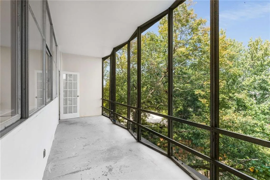 Unfurnished sunroom with floor to ceiling windows and concrete flooring