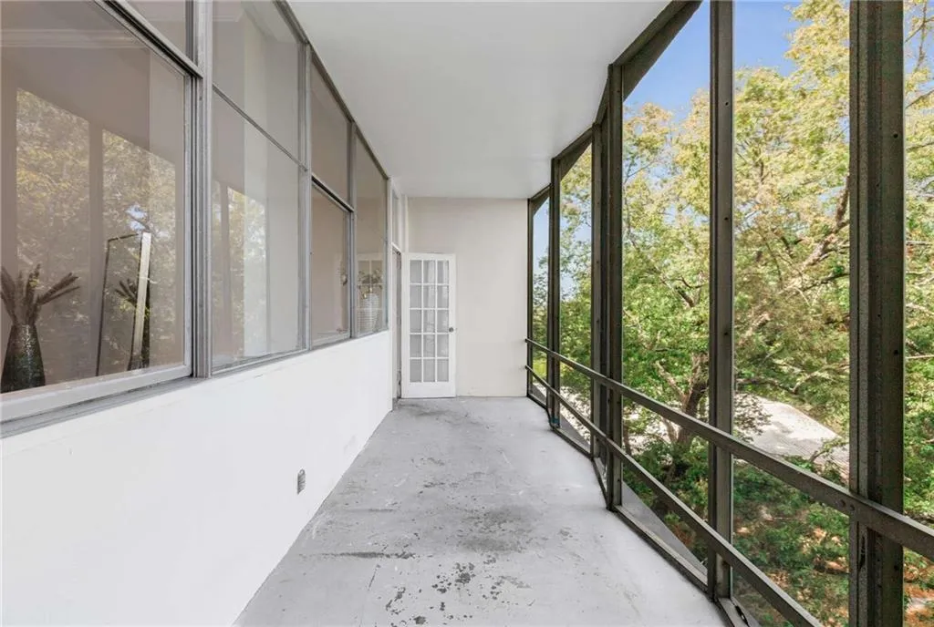 Unfurnished sunroom with concrete flooring, plenty of natural light, and a balcony
