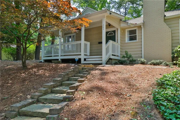 Covered front porch with white railing, brick chimney, and durable siding exterior
