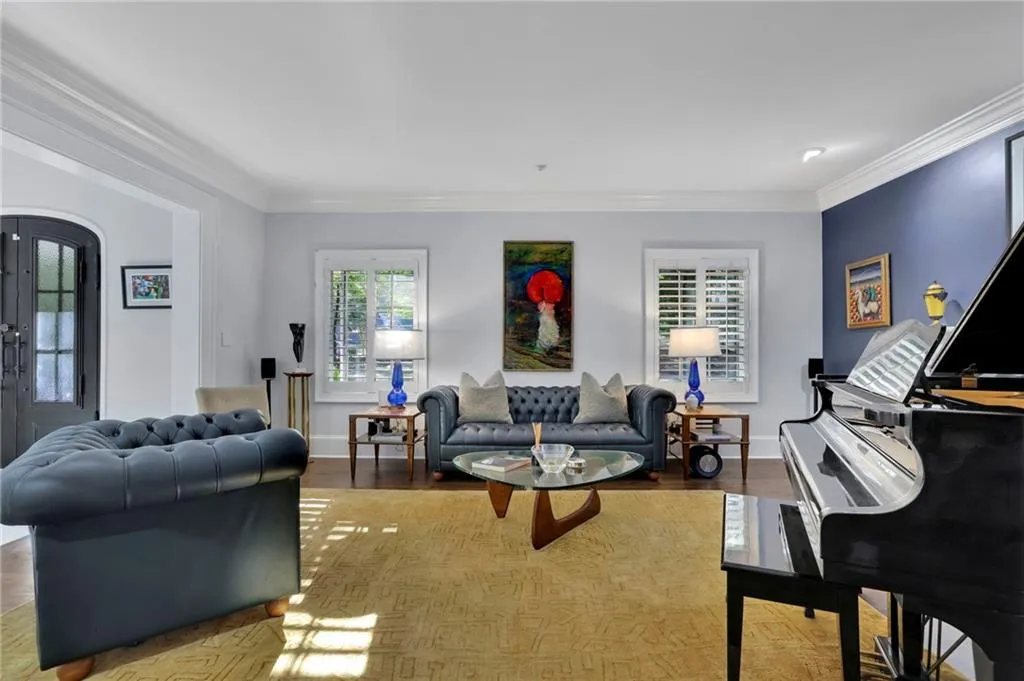 Sitting room with crown molding, a chandelier, wood finished floors, and a fireplace