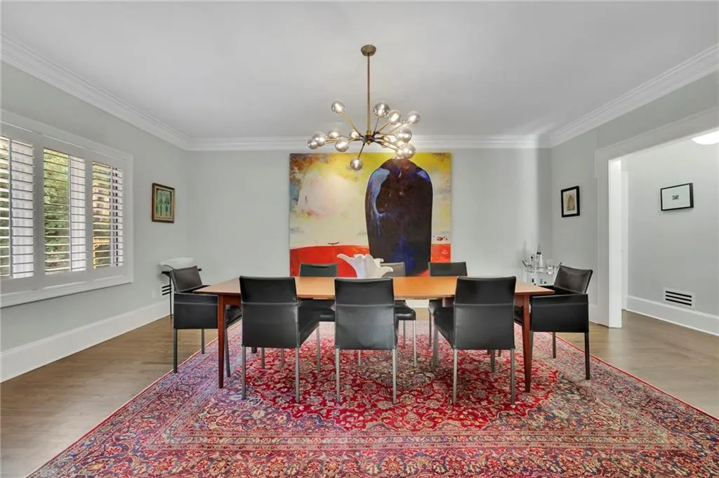 Dining room with ornamental molding, light wood-type flooring, and a chandelier