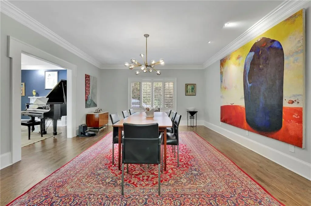 Living area with ornamental molding, stairs, and wood finished floors