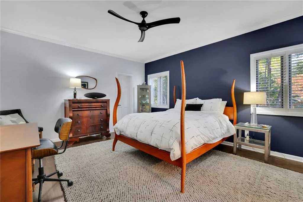 Bedroom featuring an office area, crown molding, a ceiling fan, and wood finished floors