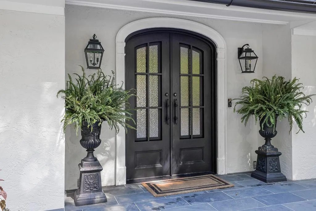 View of exterior entry featuring french doors and stucco siding