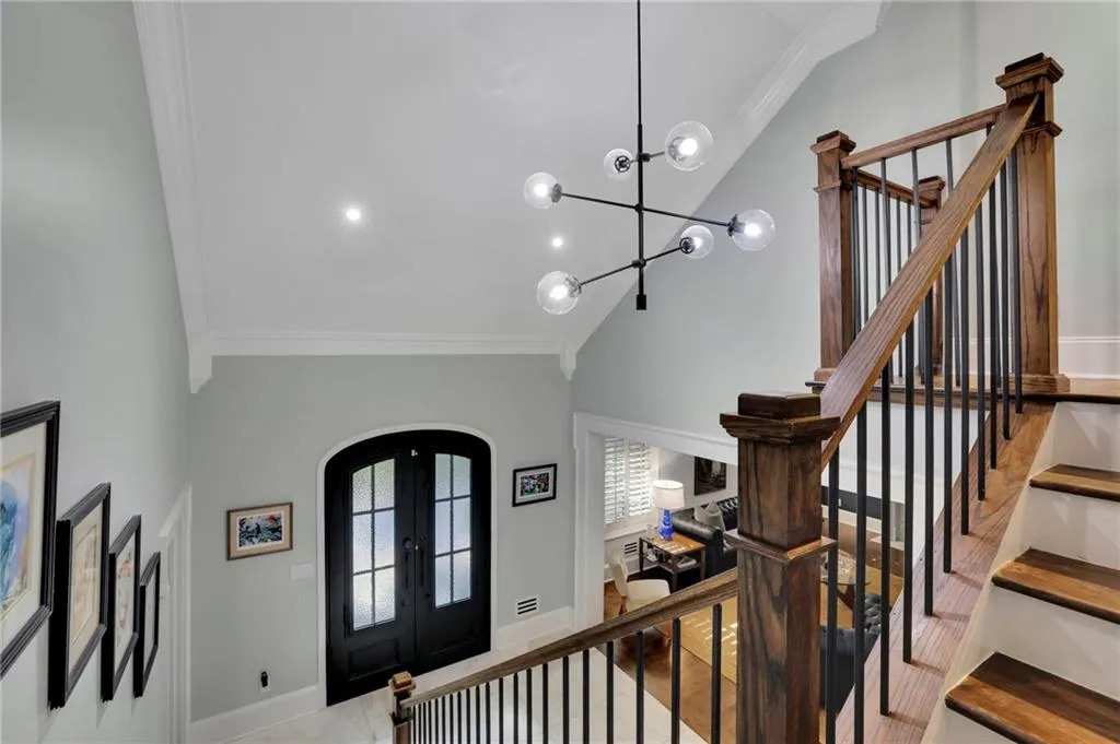 Stairs with crown molding, french doors, a chandelier, high vaulted ceiling, and recessed lighting