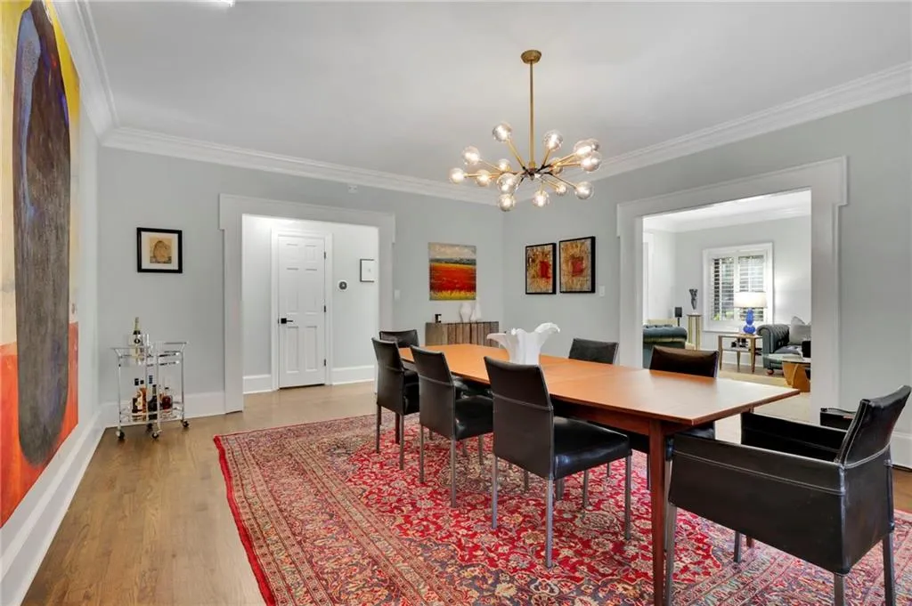 Dining area with a chandelier, dark wood-style floors, and crown molding