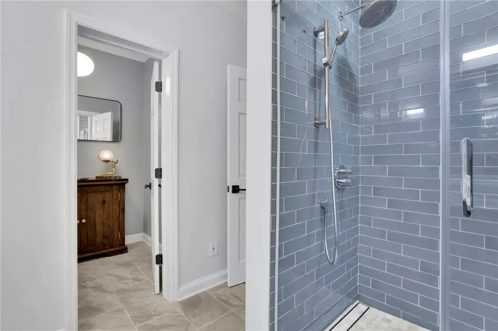 Bathroom with a stall shower and ornamental molding