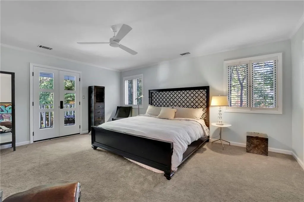 Carpeted bedroom featuring crown molding, multiple windows, access to outside, and ceiling fan