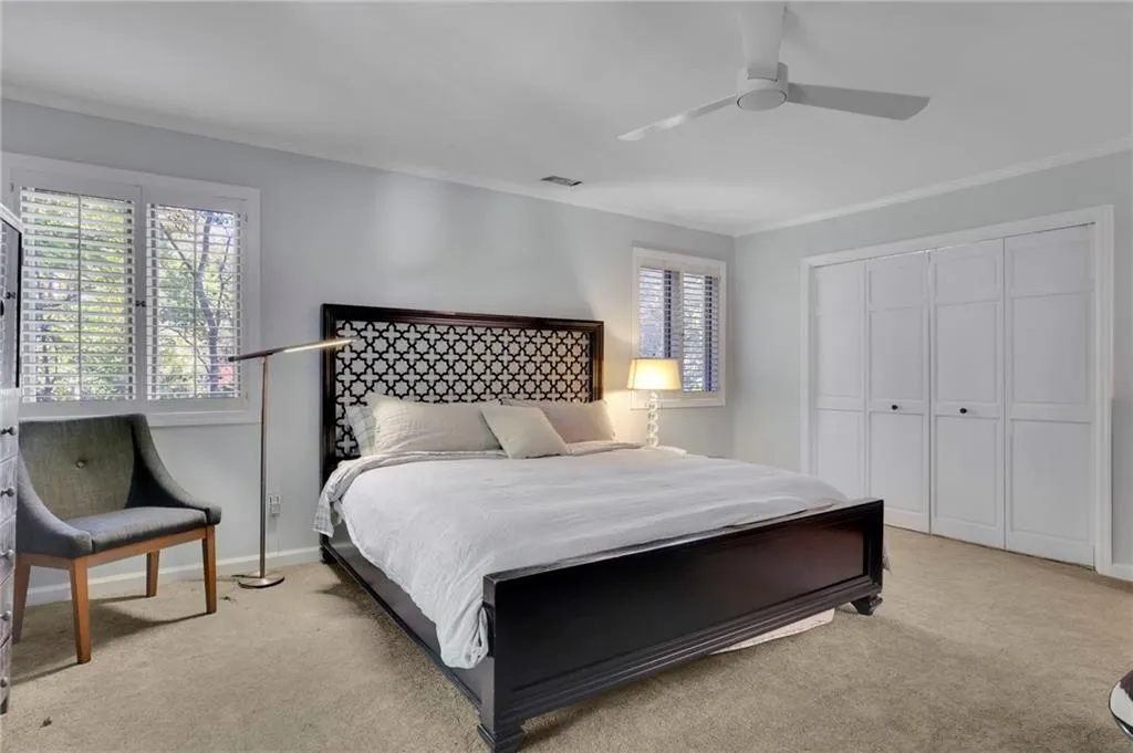 Bedroom featuring ornamental molding, a closet, carpet flooring, and ceiling fan