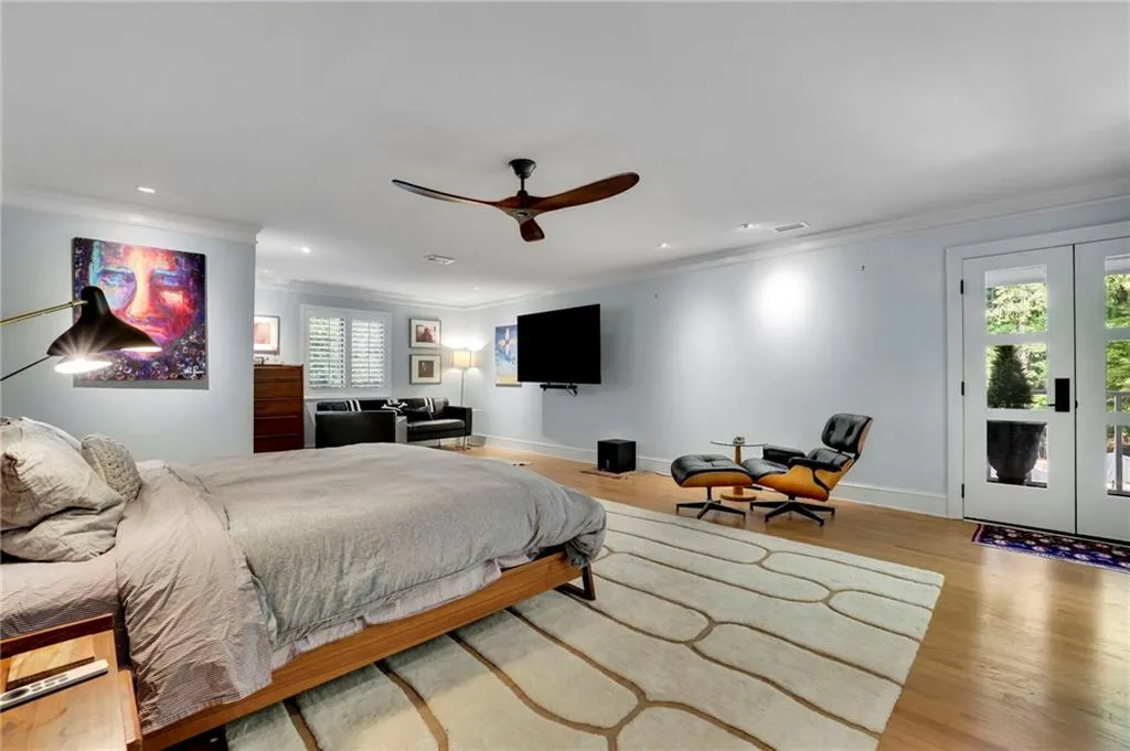 Bedroom featuring access to exterior, crown molding, wood finished floors, french doors, and ceiling fan