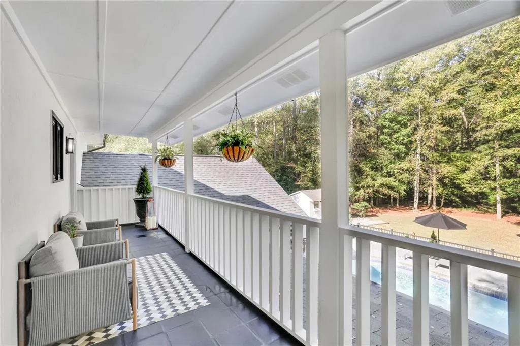 Balcony with view of pool area and view of scattered trees