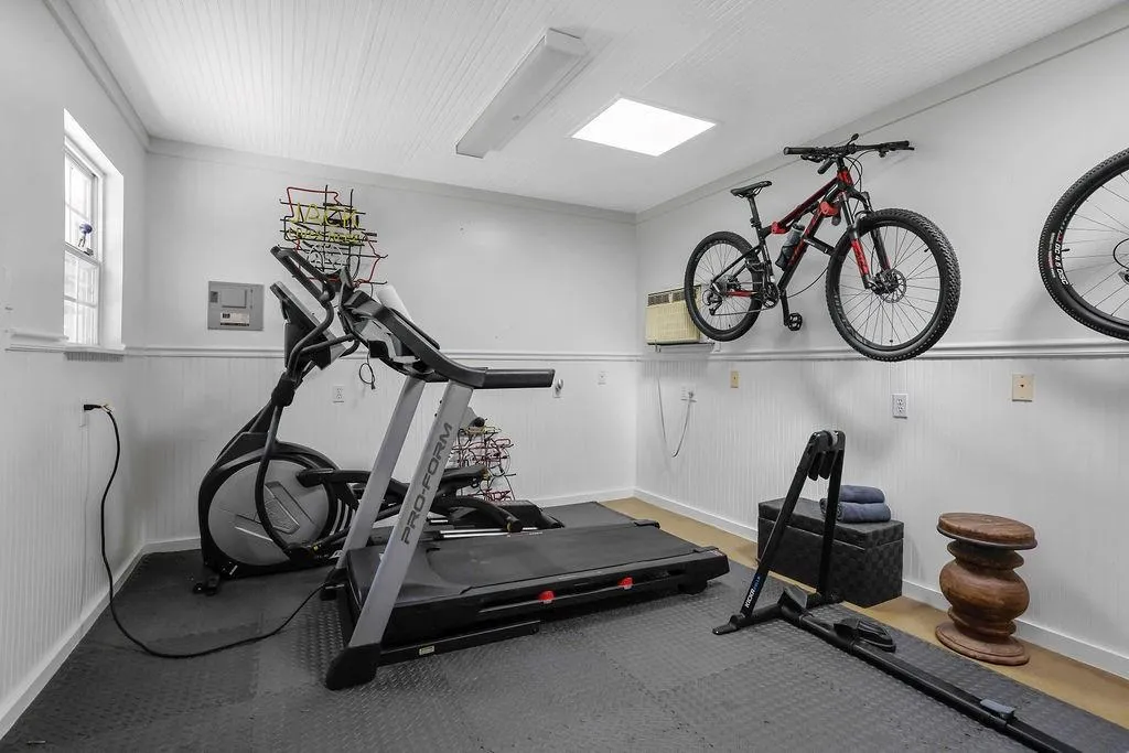 Workout area with a wainscoted wall, ornamental molding, and a wall mounted AC