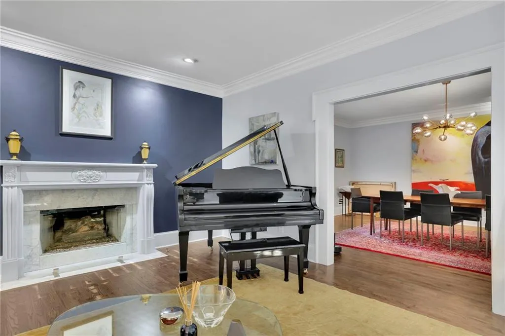 Living room with crown molding, wood finished floors, a fireplace, and recessed lighting