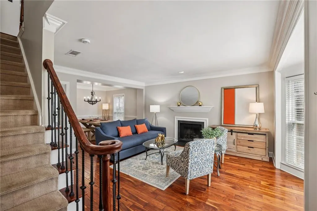 Living room featuring crown molding, a fireplace, hardwood / wood-style floors, and hanging lights