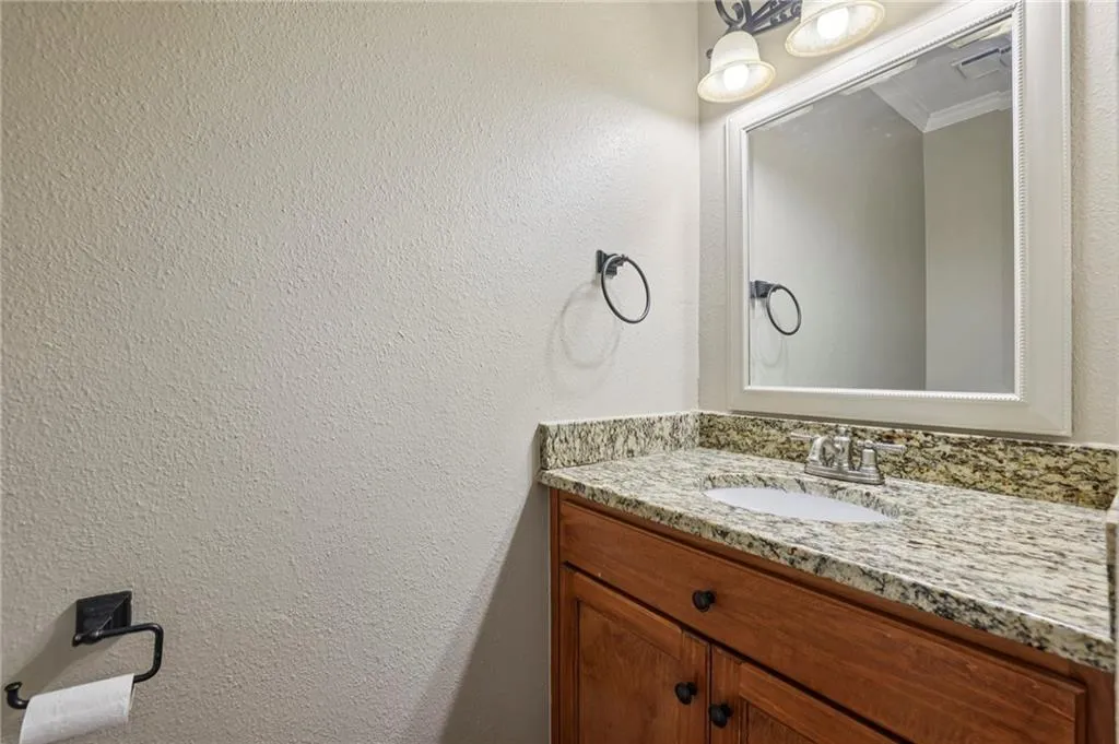 Bathroom with vanity, a textured wall, and crown molding