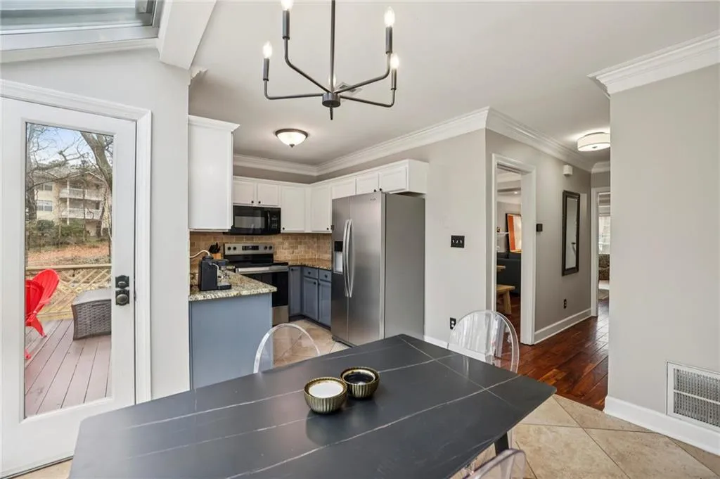 Dining space featuring hanging lights, light tile patterned floors, and ornamental molding