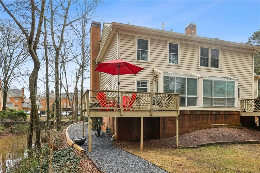 Rear view of house featuring a chimney and a wooden deck