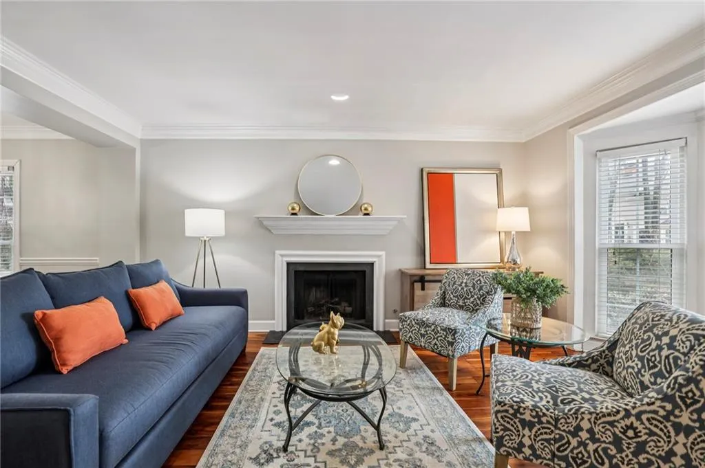Living room featuring ornamental molding, plenty of natural light, a fireplace, dark wood-style floors, and recessed lighting