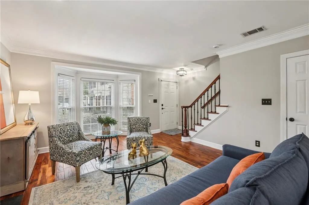 Living room with dark wood finished floors and ornamental molding
