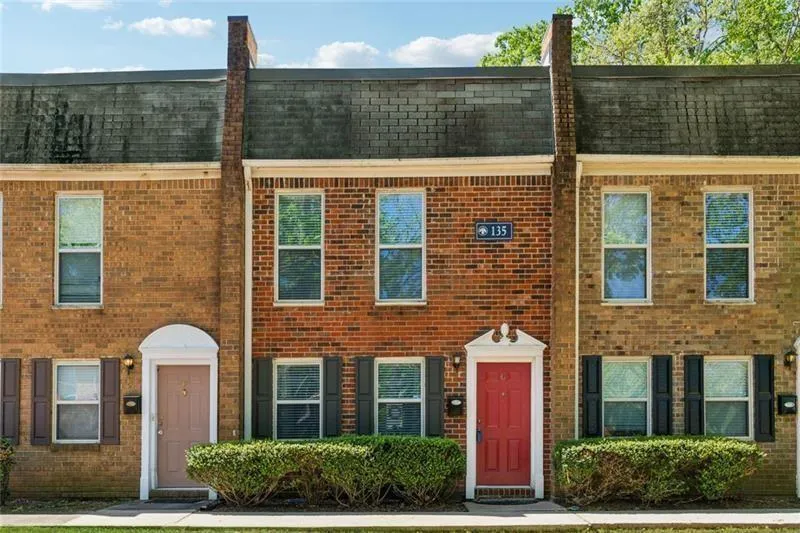 Colonial house with roof with shingles, mansard roof, and brick siding