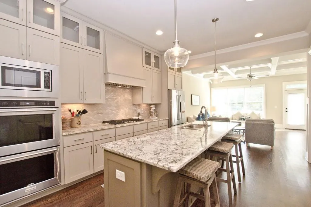 Kitchen with stainless steel appliances, a sink, open floor plan, coffered ceiling, and recessed lighting