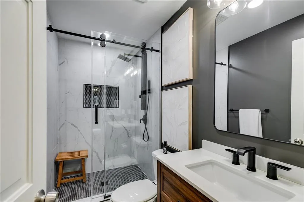 Full bath with a marble finish shower and vanity