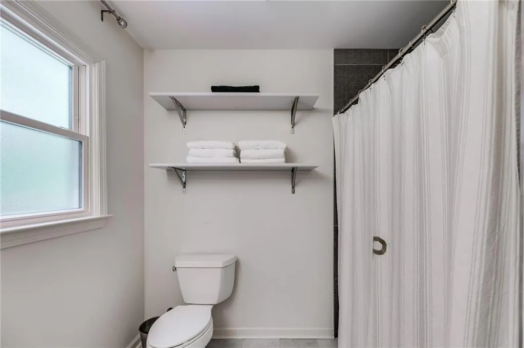 Full bath with toilet and curtained shower