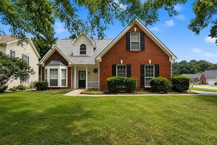 Charming brick Colonial with distinctive gabled roofline and complementary siding accents
