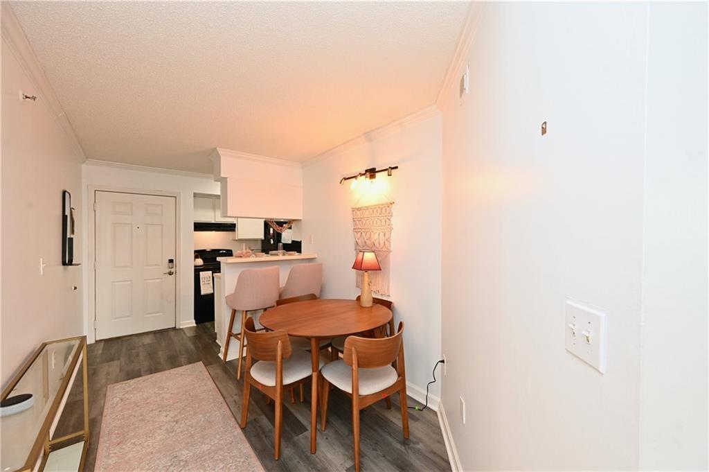 Dining area with crown molding and dark hardwood / wood-style flooring