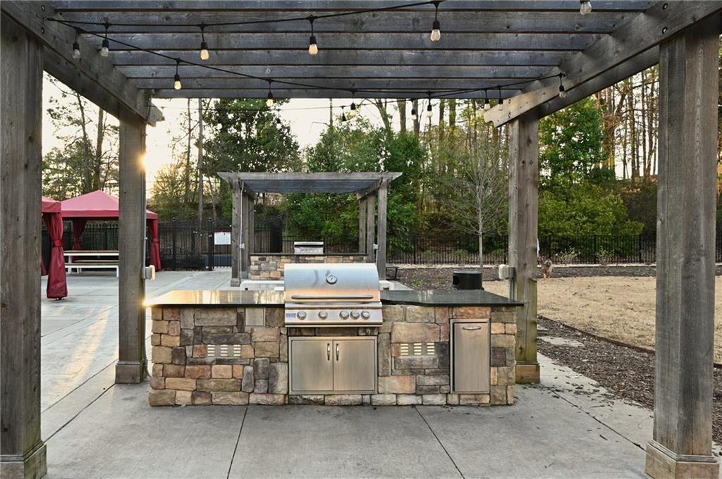 View of patio featuring area for grilling, a pergola, and a gazebo